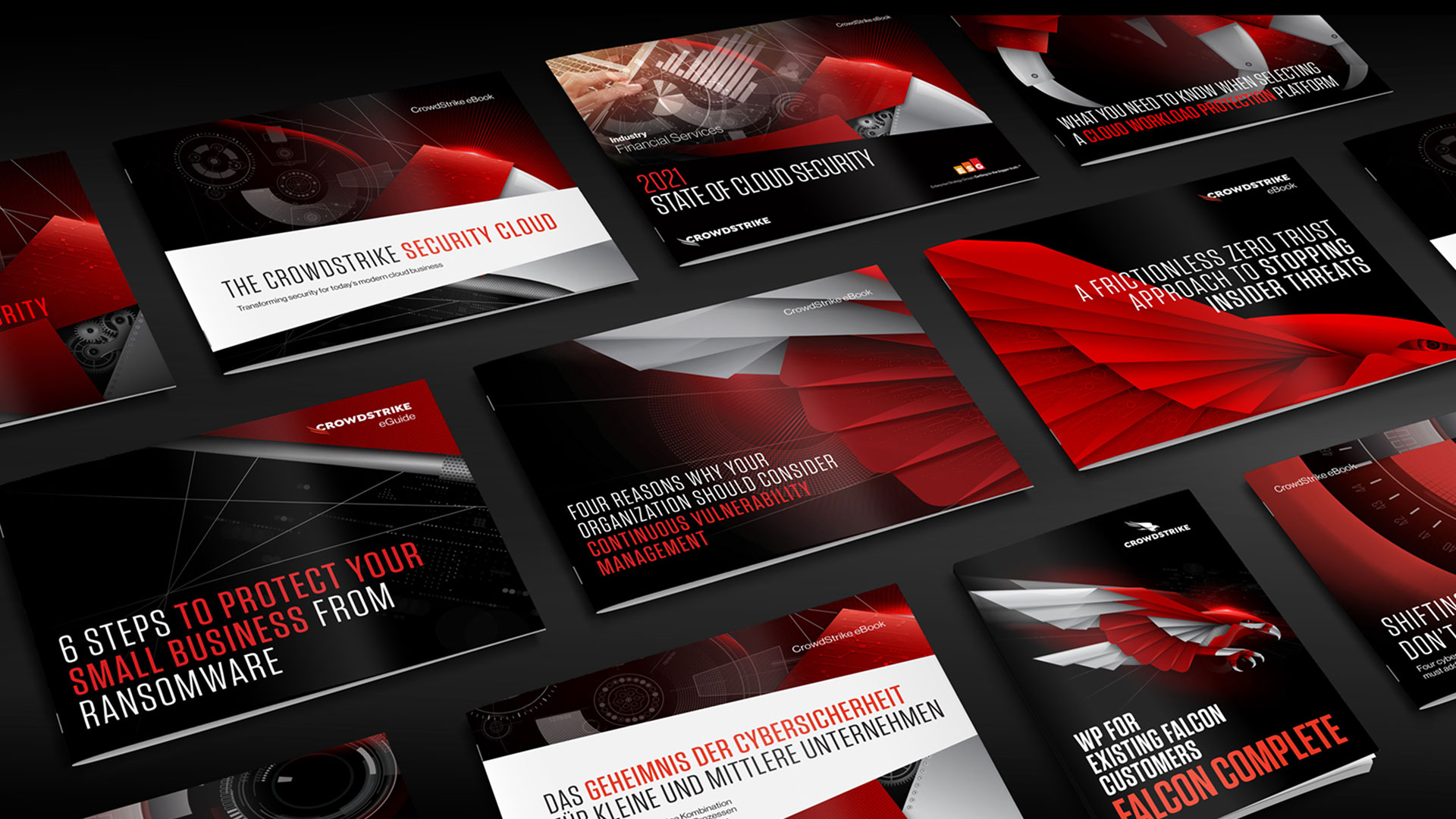 A flat lay collection of printed CrowdStrike e-books and white papers, showcasing various cover designs that incorporate the red and black mechanical falcon graphics.