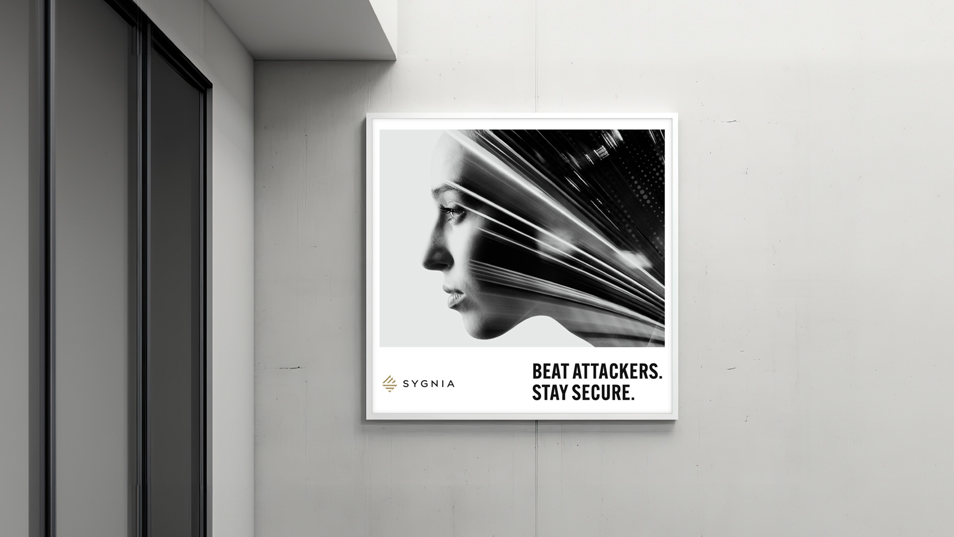 An illuminated square wall sign in a modern concrete hallway displaying a Sygnia advertisement with a double exposure portrait and the headline 'Beat Attackers. Stay Secure.'
